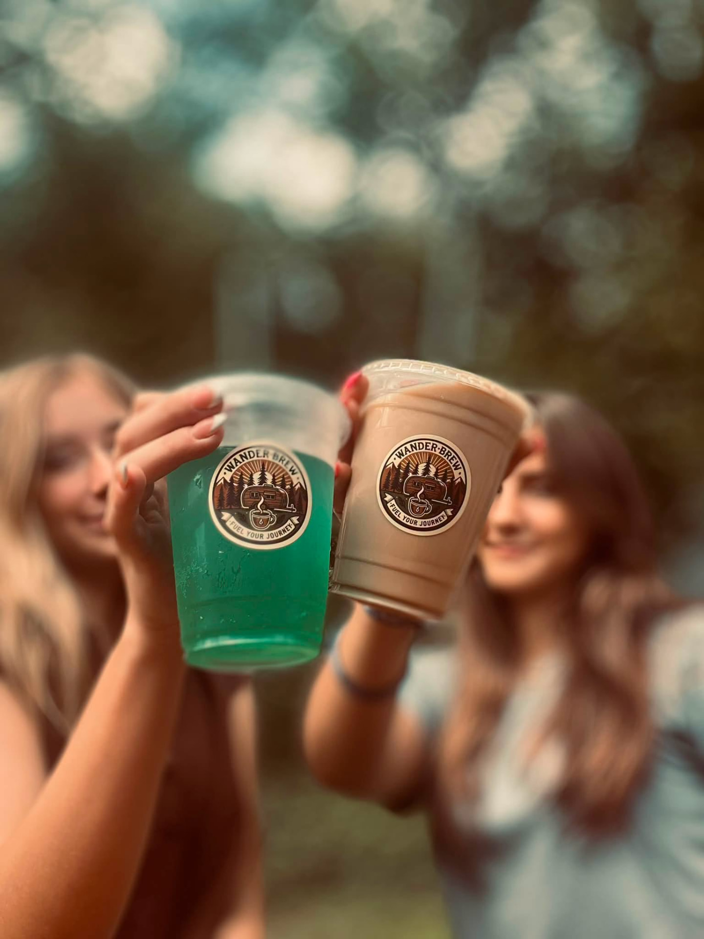 Two WanderBrew customers raising branded iced drinks together